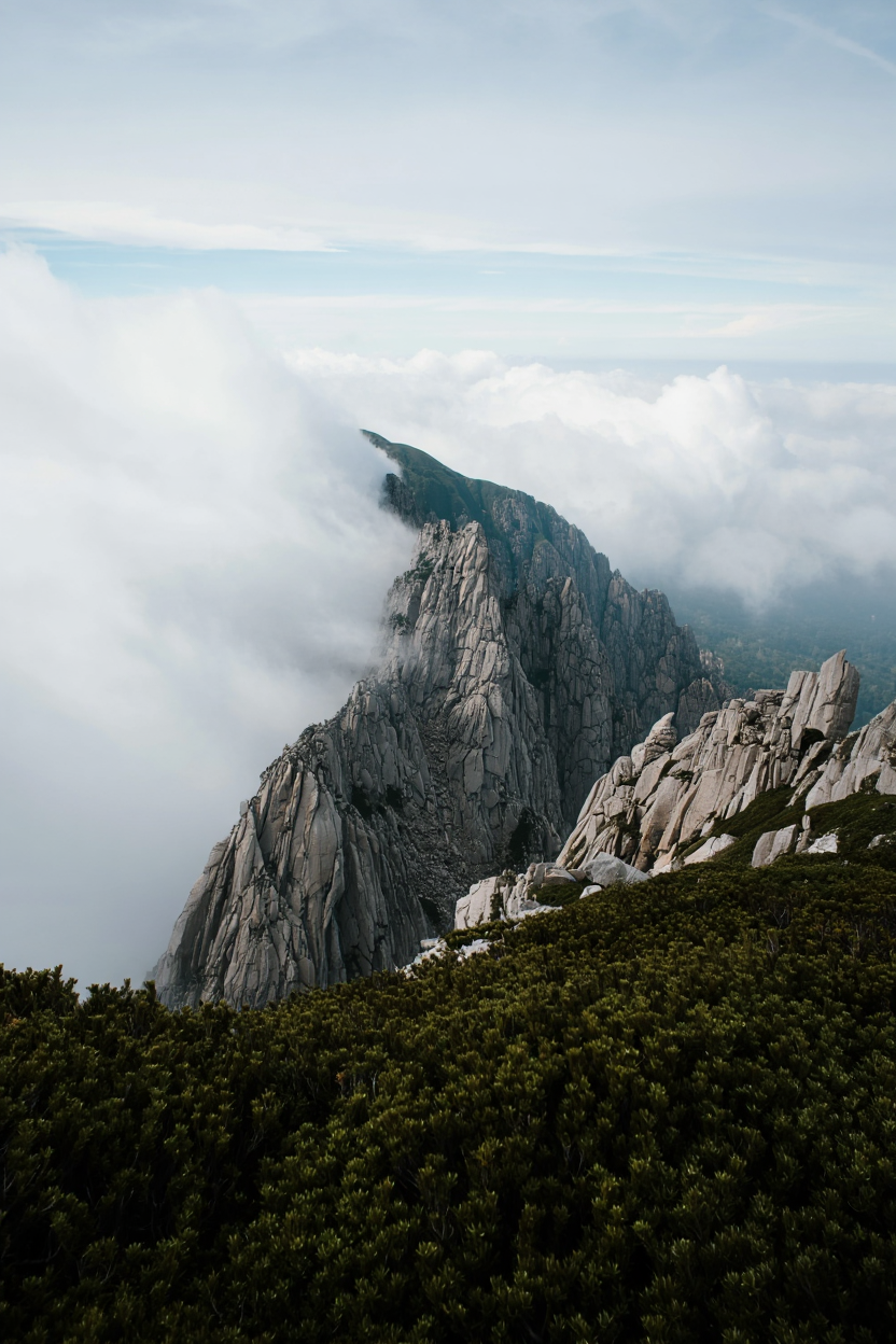 Rocky mountain peak with steep granite or limestone cliff faces and jagged formations