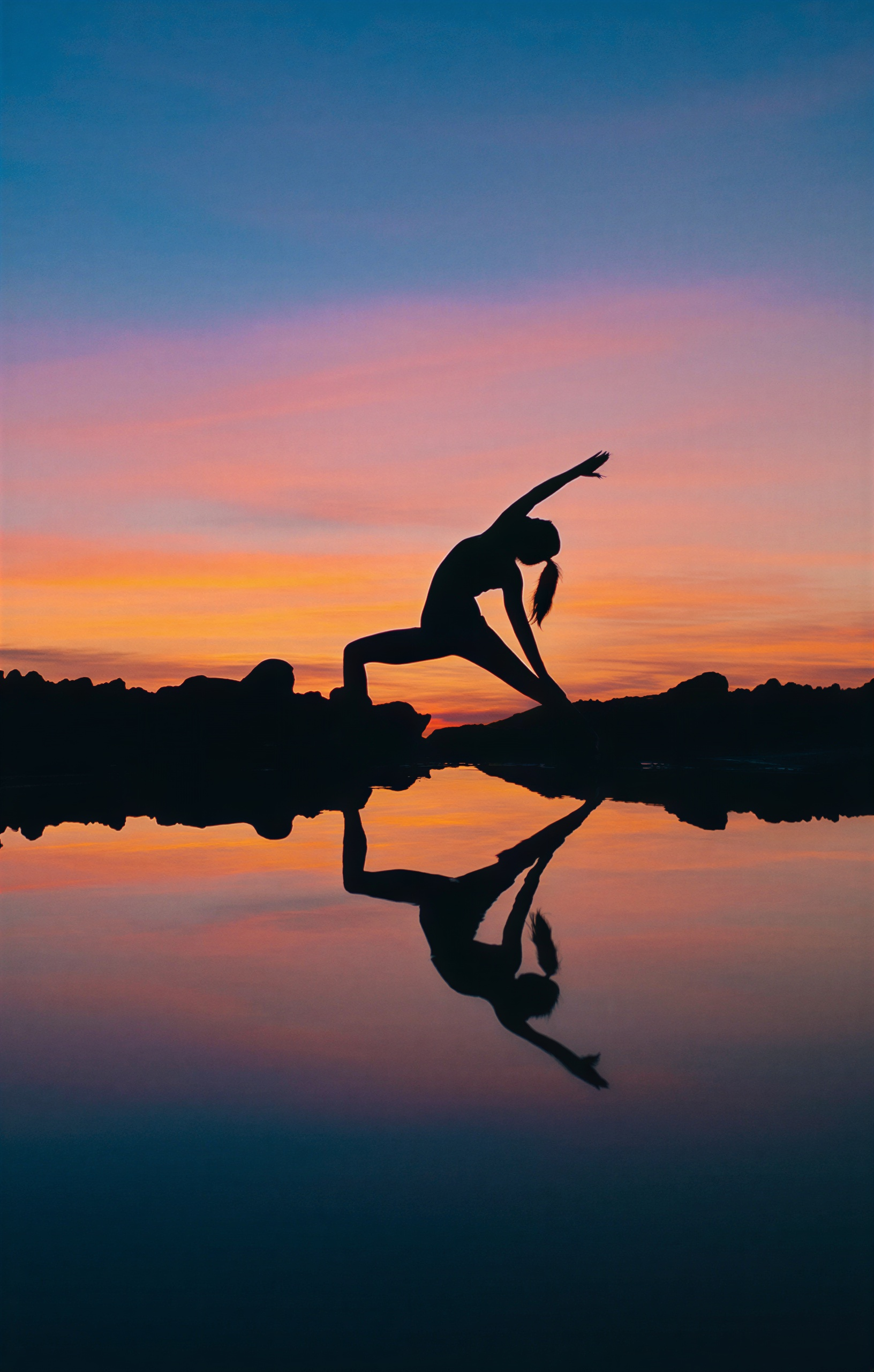 Serene yoga silhouette with sunset reflection